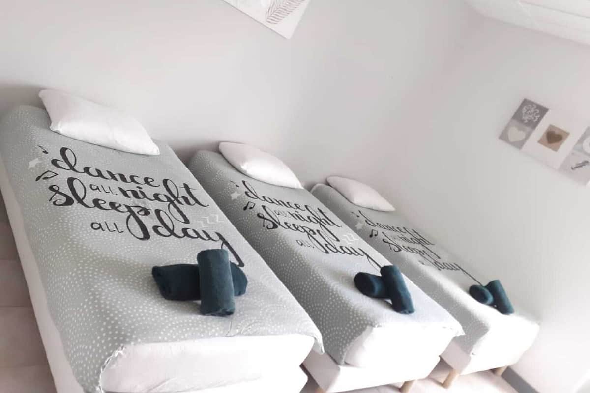 Trois tables de massage, équipées de coussins et de serviettes, et chacune agrémentée d’une citation inspirante.