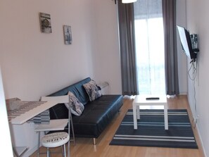 Apartamento, 1 habitación, balcón, vistas a la ciudad | Sala de estar | Una televisión