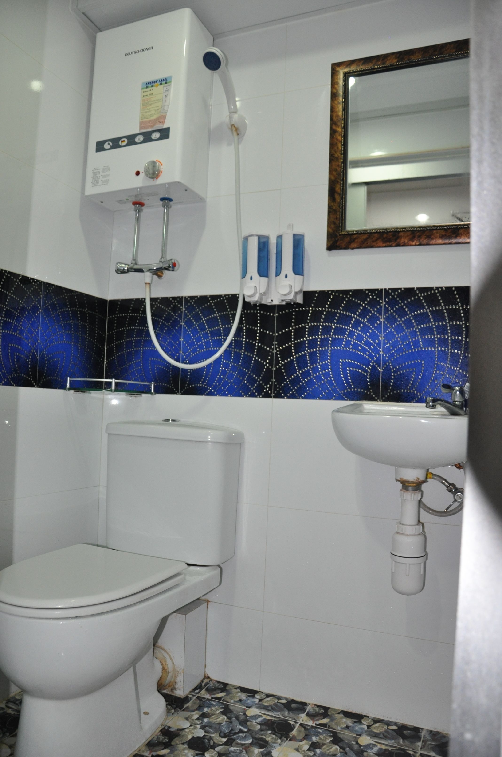 A bathroom with a toilet, a sink, and a shower unit.