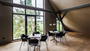 Een modern interieur met grote ramen, een schuine plafond en een houten vloer.