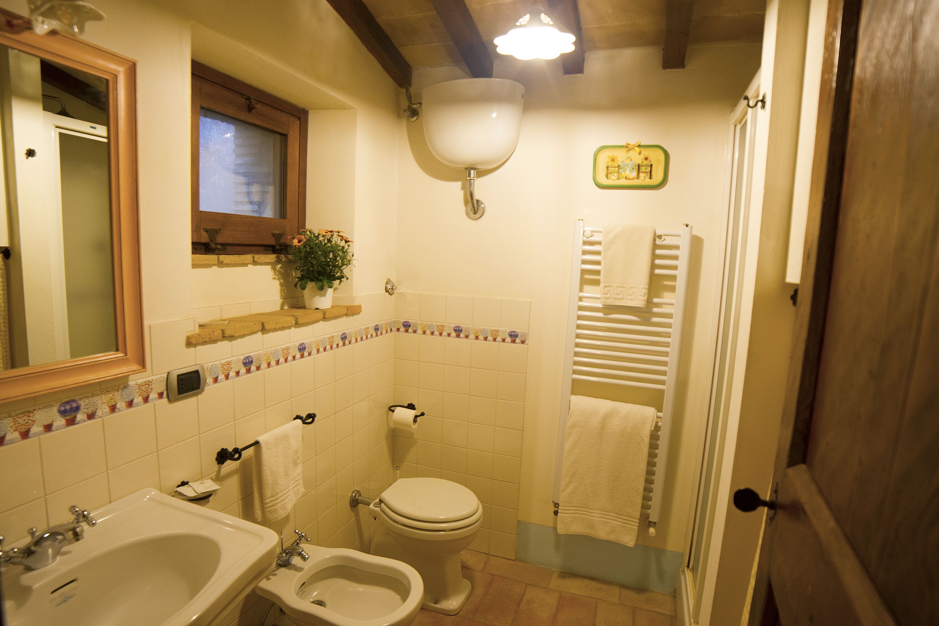 A bathroom with a sink, bidet, toilet, and a mirror.
