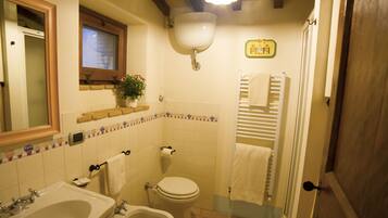 A bathroom with a sink, bidet, toilet, and a mirror.