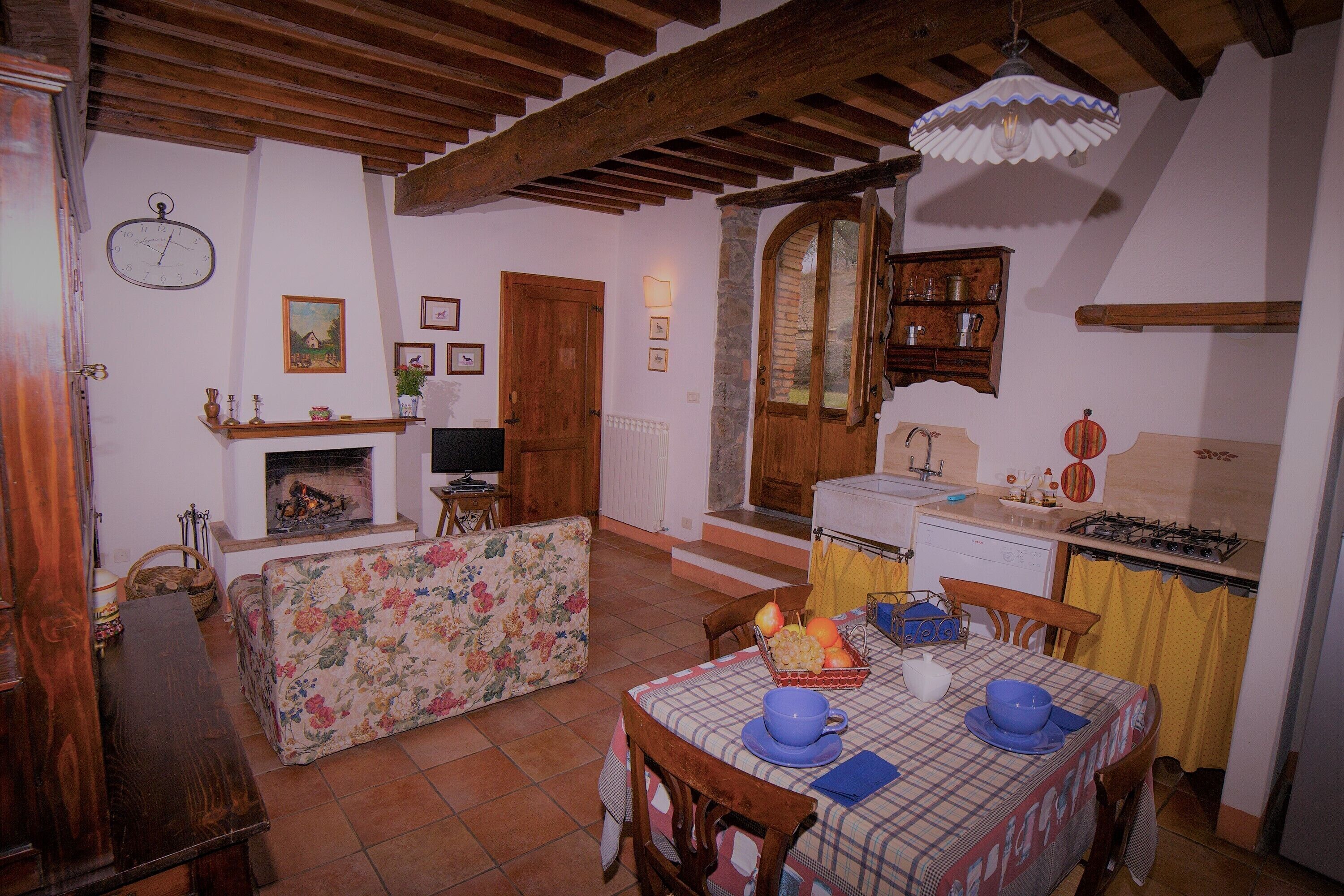 A cozy kitchen with a dining table, chairs, and a fireplace.