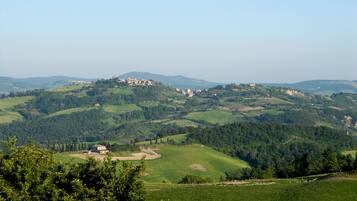 A panoramic view of a hilly landscape with scattered buildings, likely a rural area with natural scenery and historical architecture.