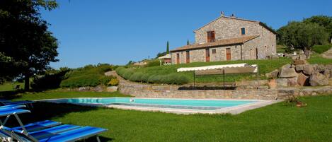 Een seizoensgebonden buitenzwembad en ligstoelen