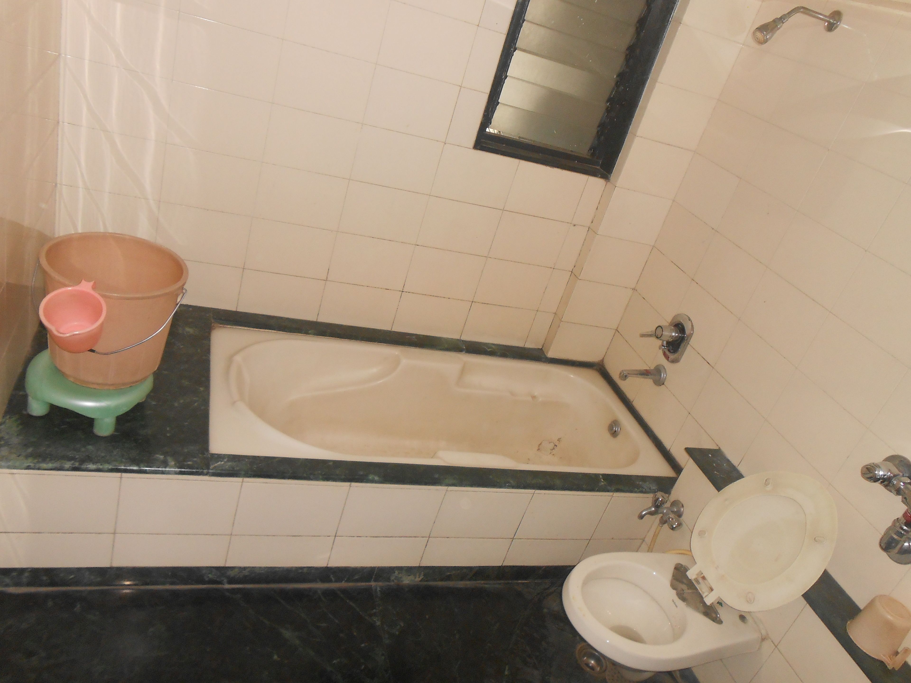 A bathroom with a bathtub, toilet, and a small sink.