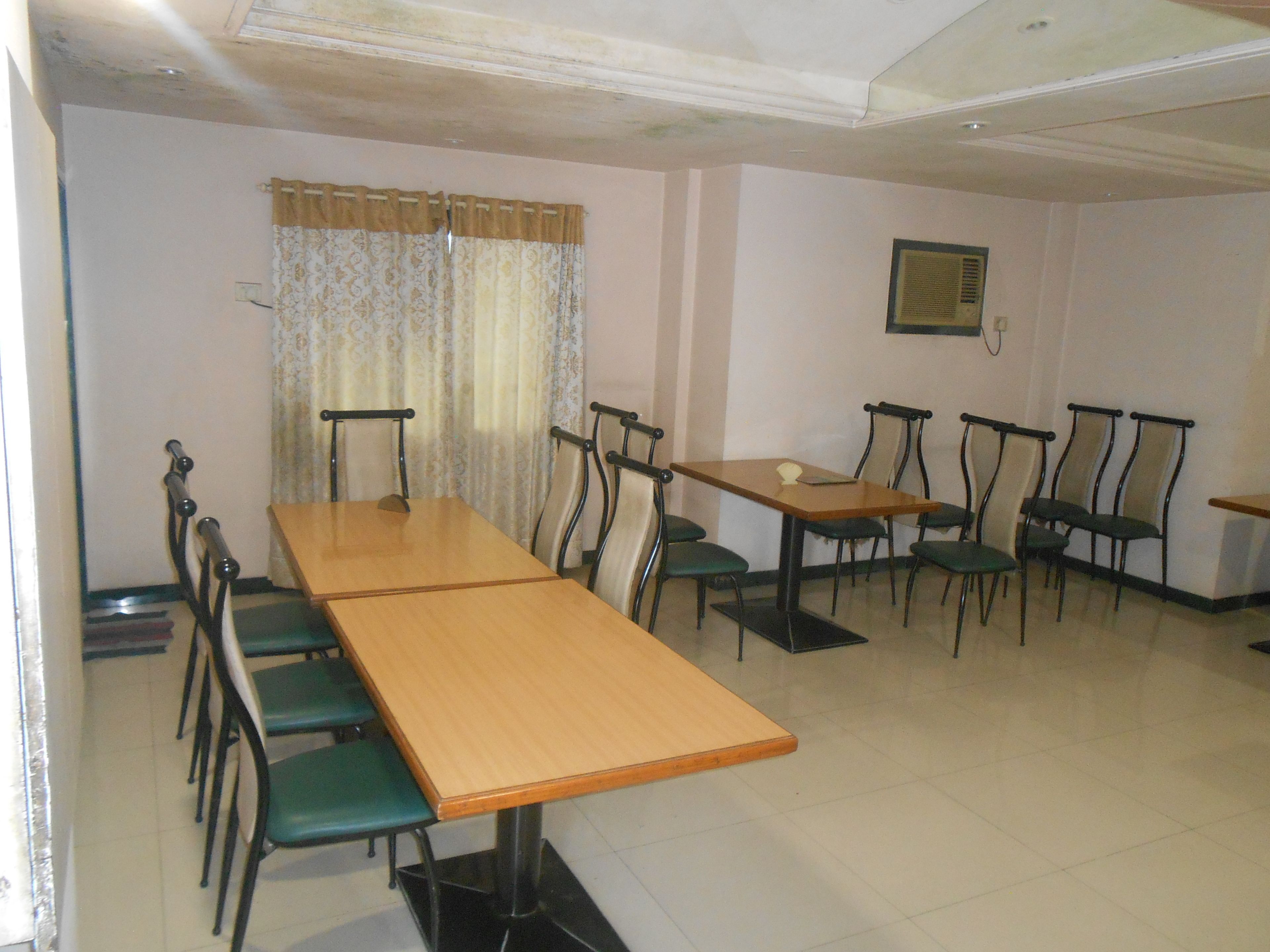 A dining area with a long wooden table and multiple chairs.