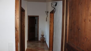 A hallway with a tiled floor, wooden doors, and a vase with reeds. - Appartement Vanii (Rust)