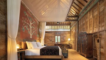 Quarto de madeira com cama, mesa e armário.