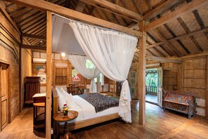 Una habitación tradicional de madera con una cama con dosel, un escritorio y una silla.