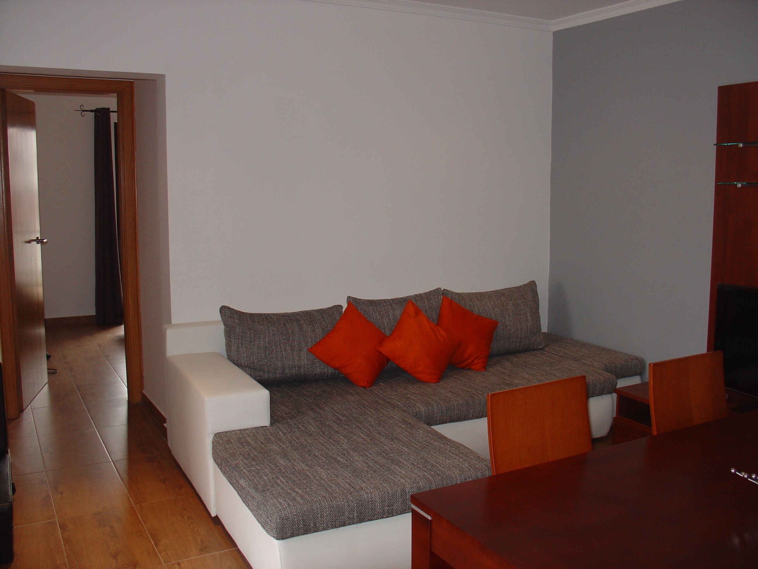 Un salon comprenant un canapé, une table à manger et un meuble en bois.