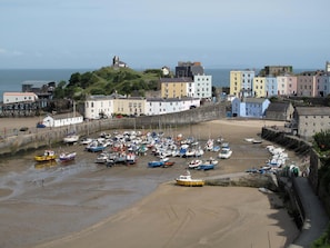 A coastal town with a sandy beach, a stone wall, and colorful buildings. - Gower View Luxury bed & Breakfast (Tenby)