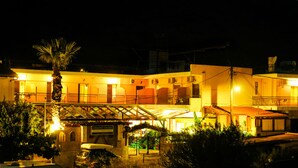 Un hotel con varios balcones, un espacio al aire libre cubierto y un cartel que indica que es un hotel.
