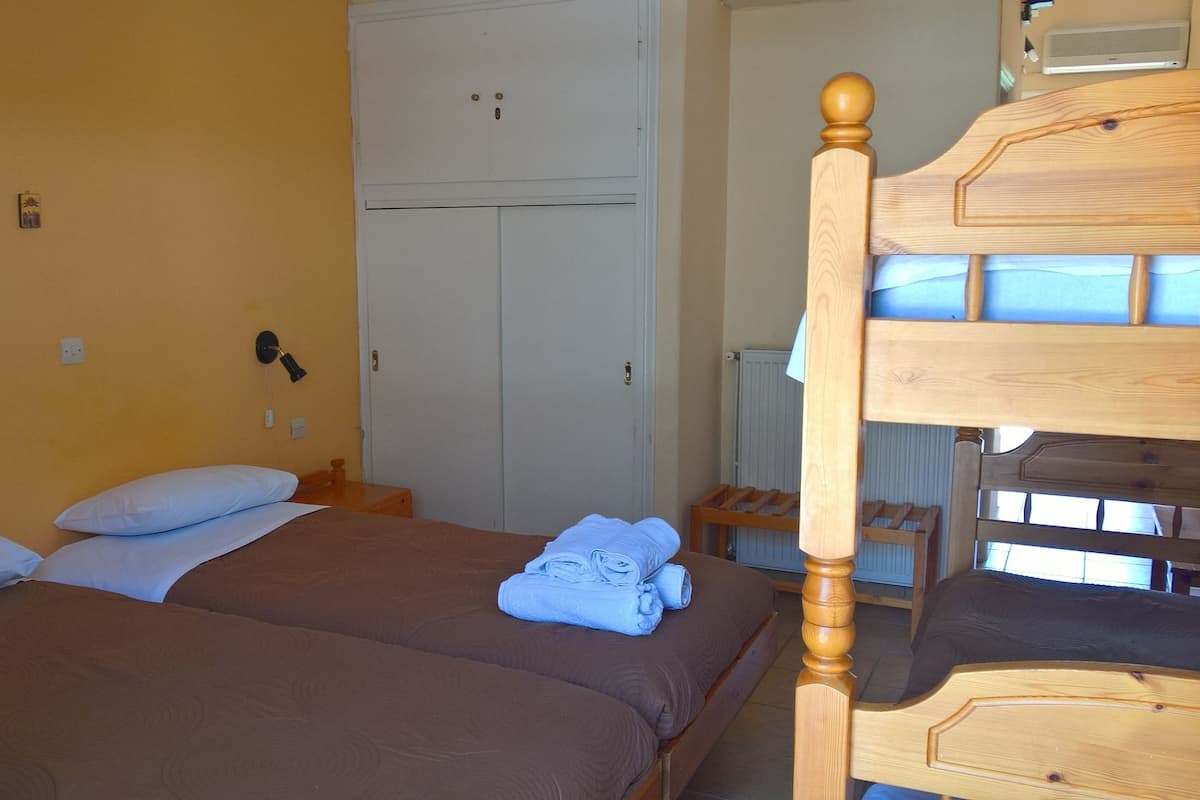 Ein Schlafzimmer mit zwei Betten, einem Kleiderschrank, einem Holzkopfende und einer Heizung.