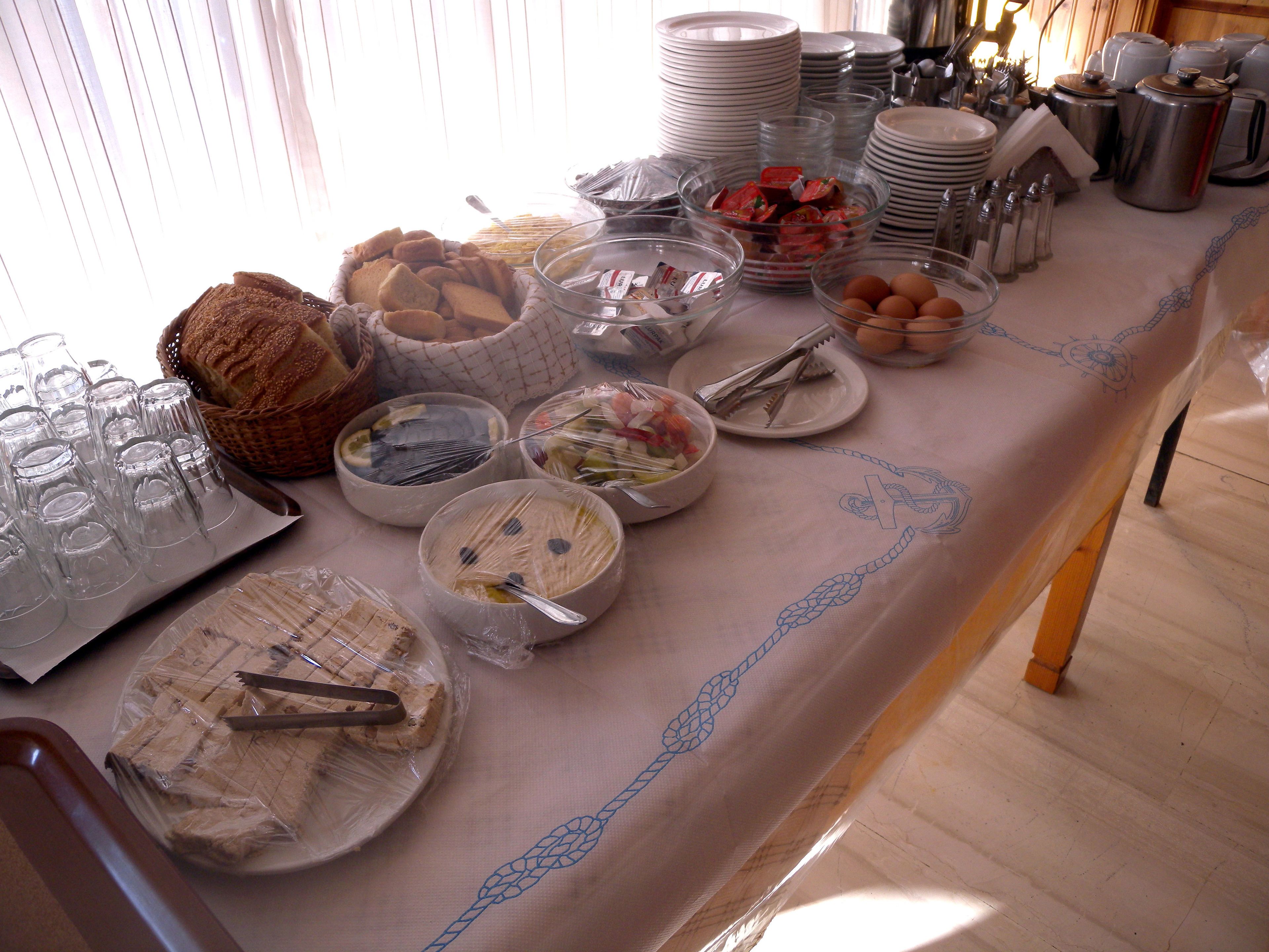 A breakfast buffet with various food items and utensils.