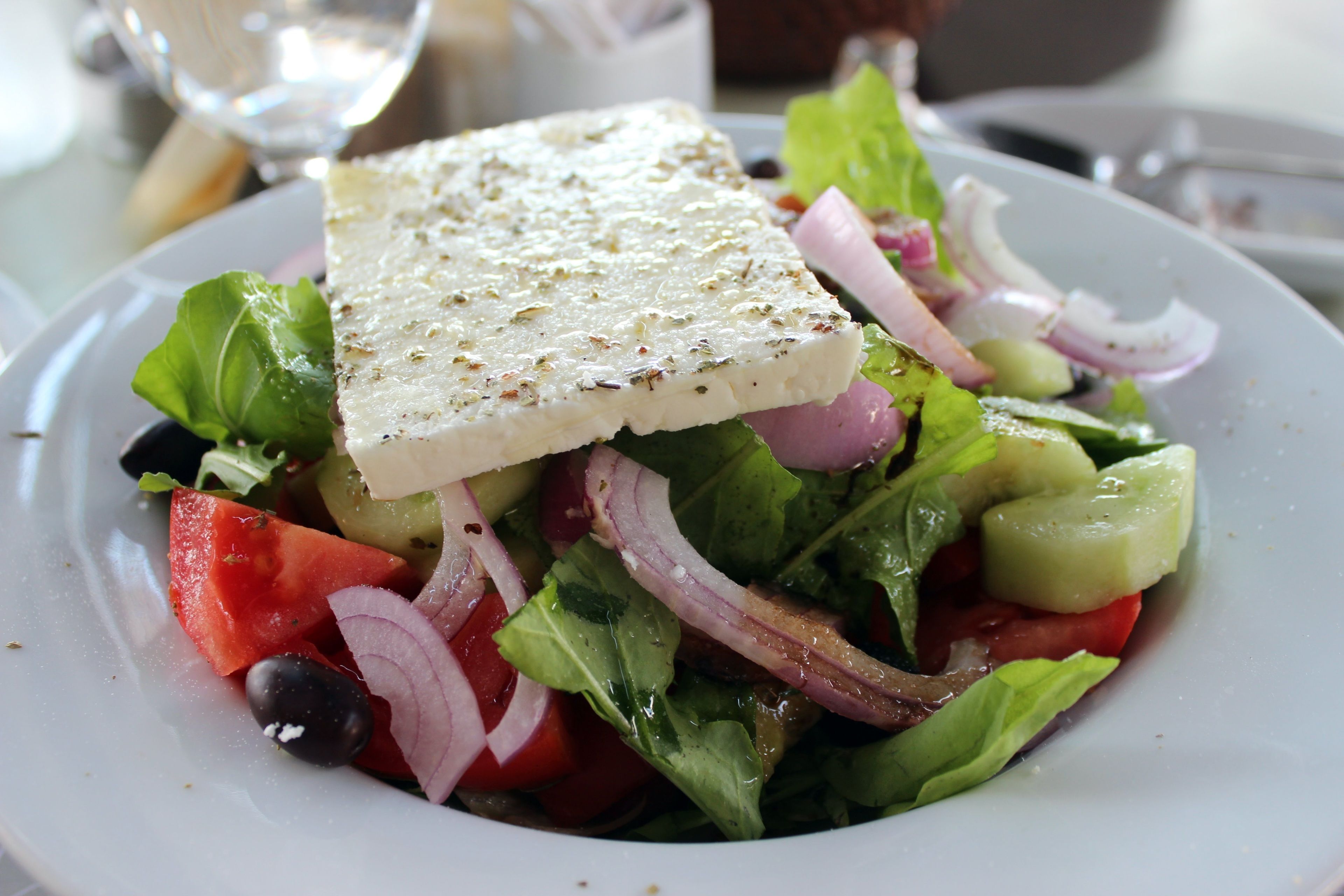 Ensalada con queso feta, tomates, pepinos y cebollas rojas.