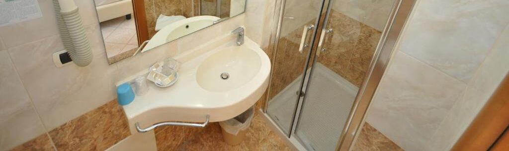 Une salle de bain équipée d’un lavabo, d’un miroir et d’une cabine de douche.