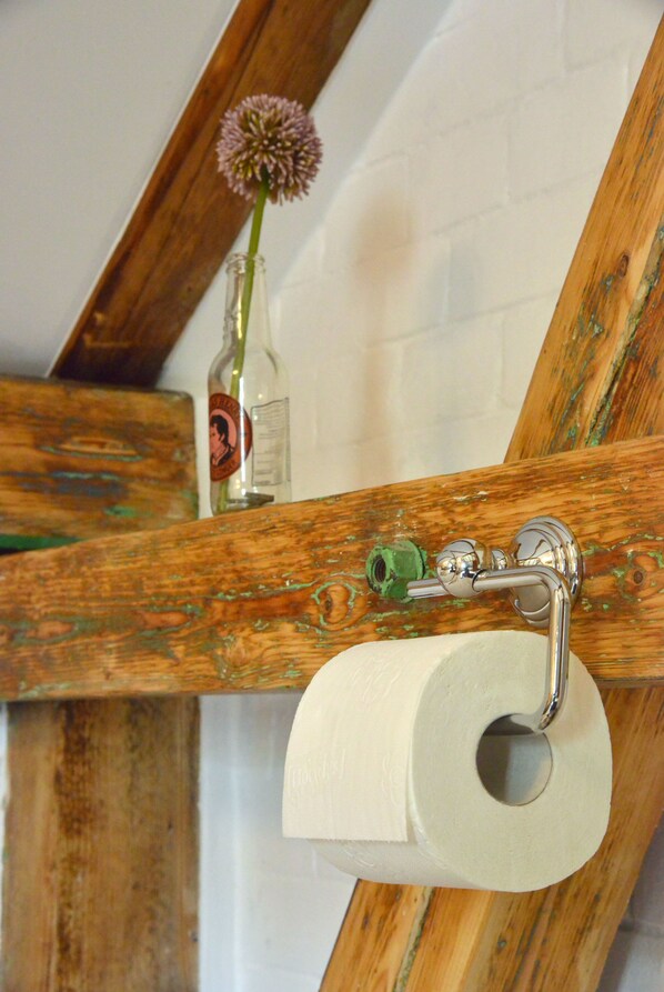 A wooden beam with a toilet paper roll and a green bottle on it. - Alte Bahnstation Leipzig (Leipzig)