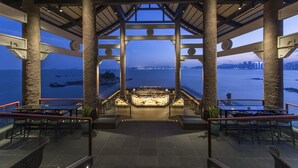 A covered outdoor bar area with a view of the sea and city skyline. - Angsana Zhuhai Phoenix Bay (Zhuhai)