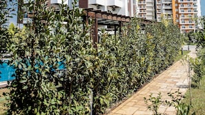 A multi-story residential building with balconies, surrounded by greenery and a clear blue sky. - Upart Home (Mersin)
