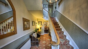 A staircase with a wooden handrail and patterned carpet, leading to an upper floor. - West End Guest House (Richmond)