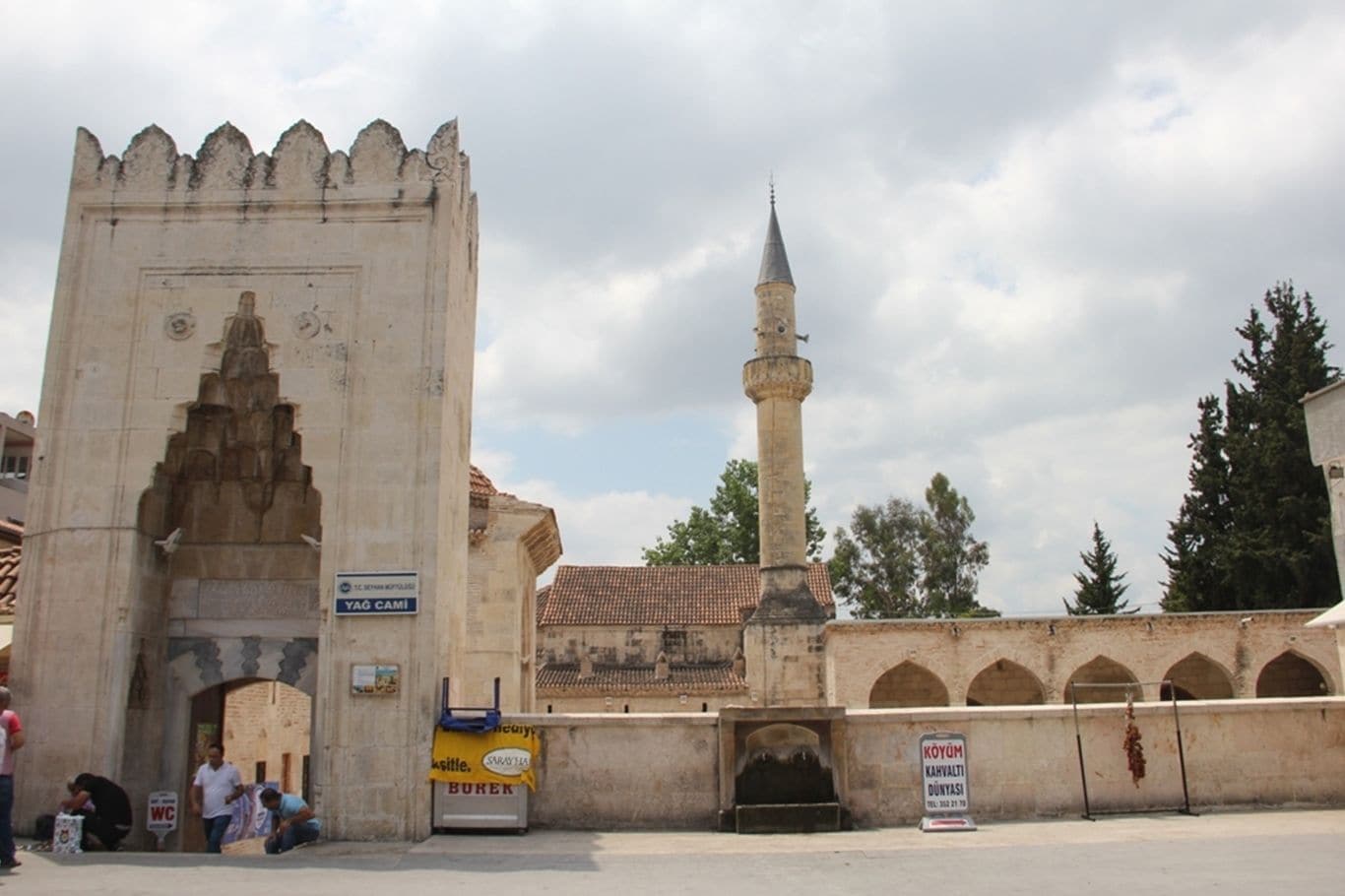 A historical gate with a tall minaret in the background.