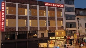 Um edifício de vários andares com a placa do Hotel Adana Saray.