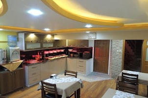 Cocina compacta con comedor, equipada con electrodomésticos modernos y dispensador de agua.