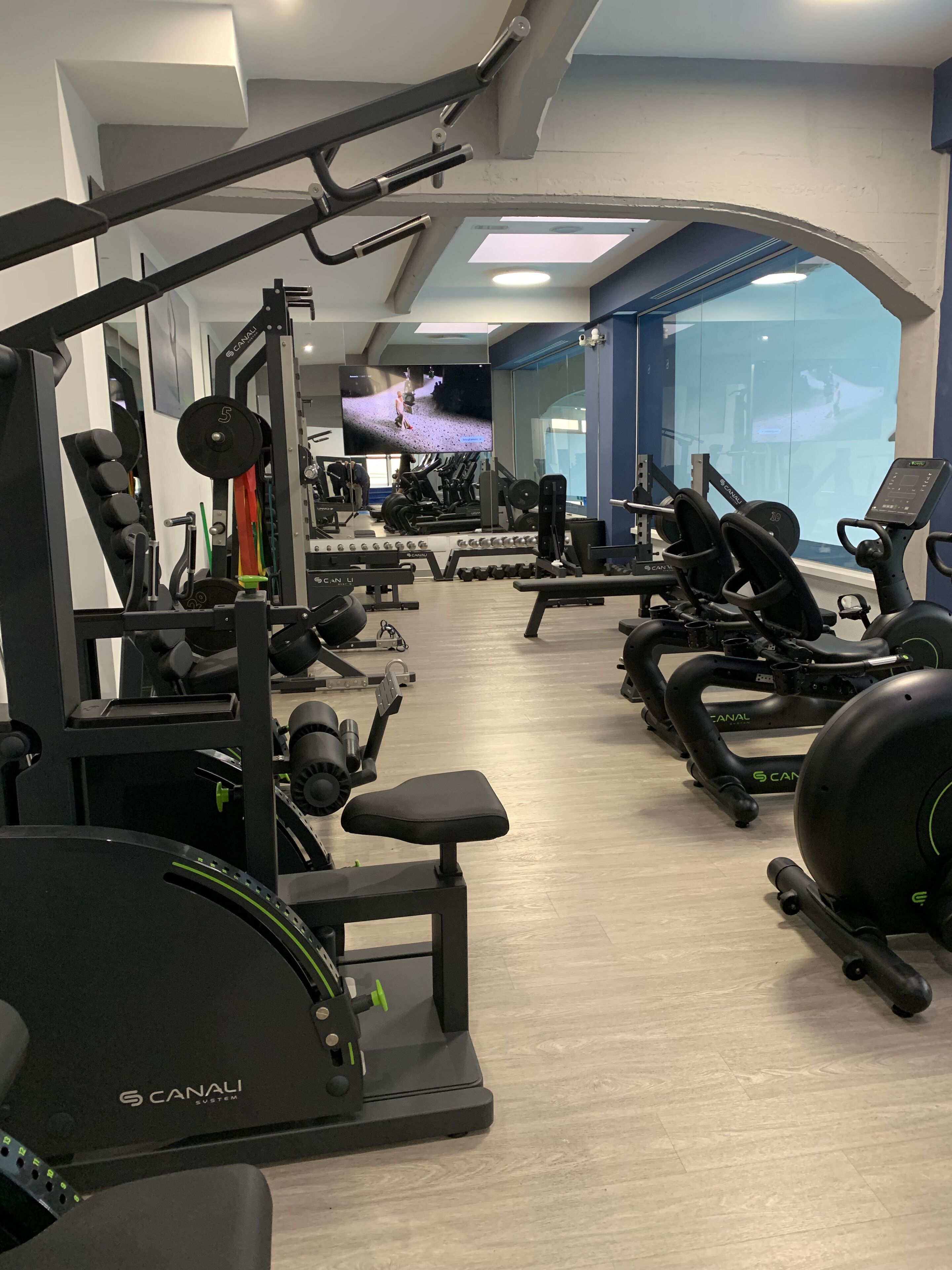 Una palestra con diverse attrezzature per esercizi, tra cui tapis roulant e macchinari per pesi.