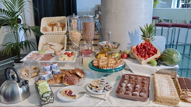 A buffet table with various food items including fruits, pastries, and desserts. - Locanda San Biagio (Misano Adriatico)