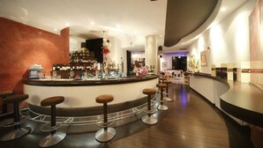 A bar area with a curved counter, multiple stools, and a variety of bottles and glasses. - Locanda San Biagio (Misano Adriatico)