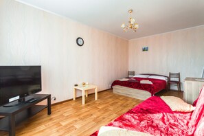 Relax in this serene bedroom with a large flat-screen TV, comfortable bed, and stylish chair.