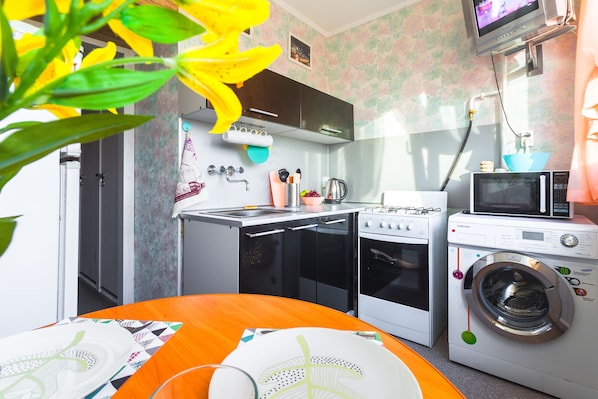 Enjoy cooking in this well-equipped kitchen with a microwave, oven, and washing machine.
