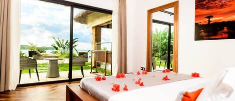 A hotel room with a bed, a large window, a balcony, and a painting on the wall.