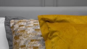 A bed with pillows in different colors.