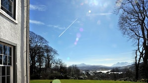 A house with a view of a lake and mountains in the distance. - The Marmalade Hotel (Portree)
