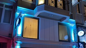 Un hotel con fachada clásica, grandes ventanales y un cartel que indica que es el Hotel Petit Troya.