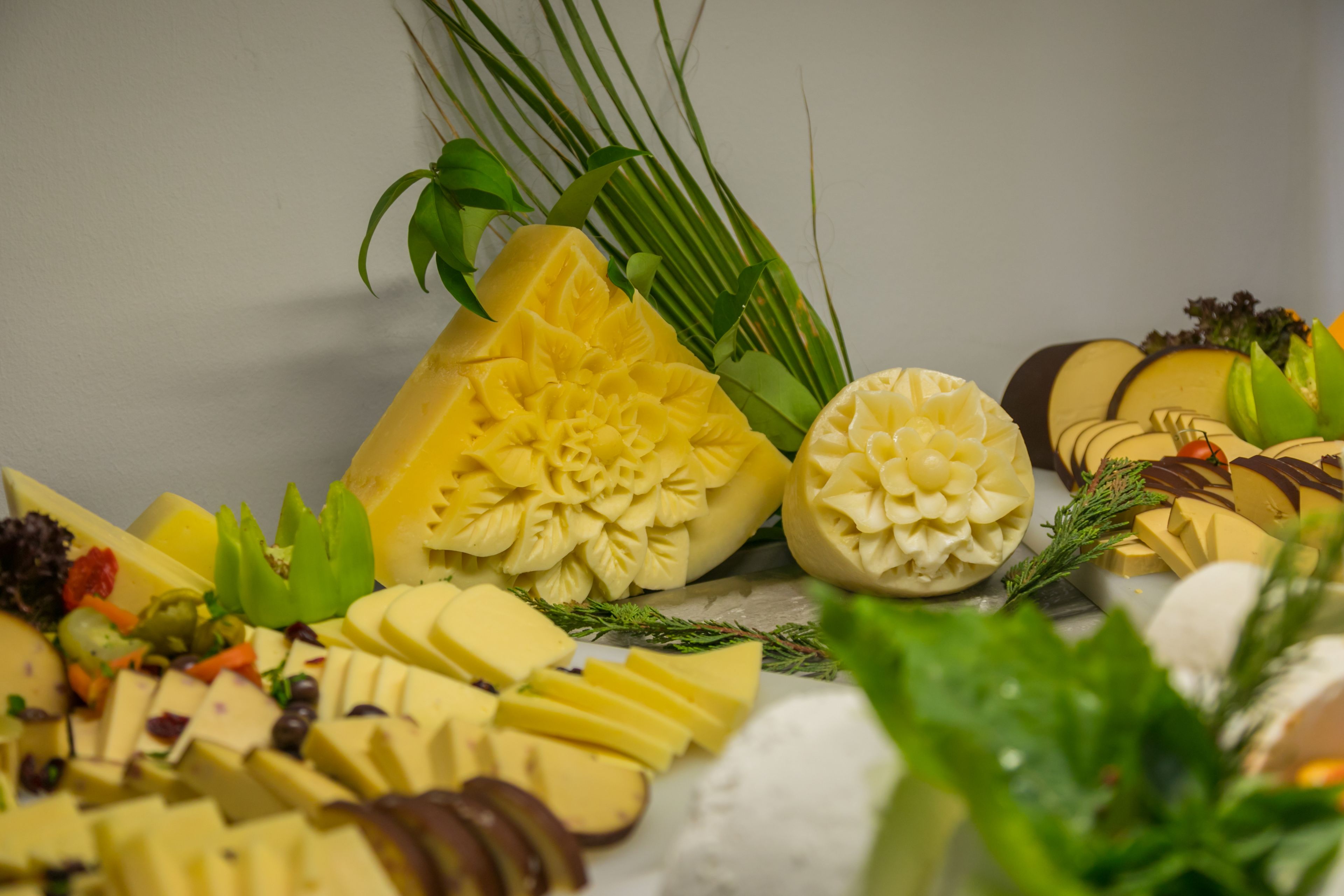 A variety of cheeses and fruits arranged on a table.
