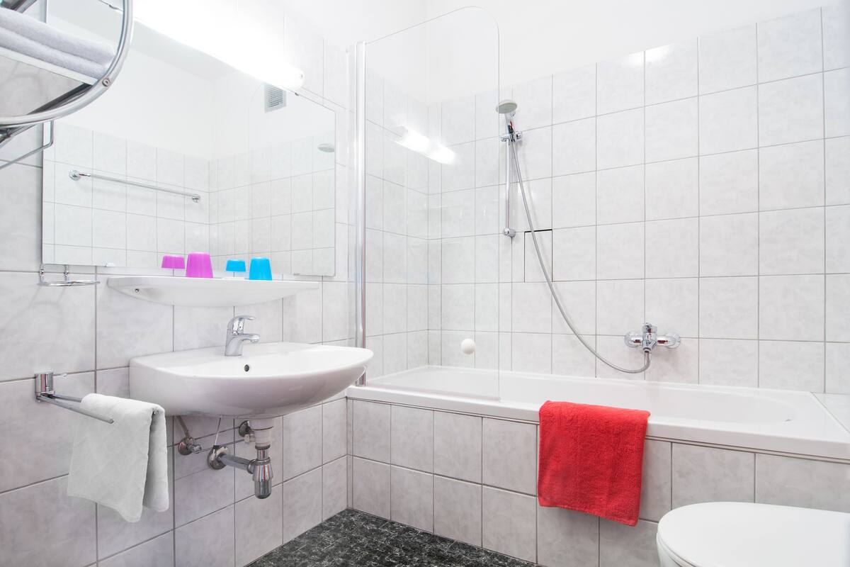 Un baño moderno con un lavamanos blanco, una bañera y un inodoro.