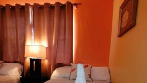 Une chambre d’hôtel avec un lit, une table de chevet, une lampe et un tableau au mur.