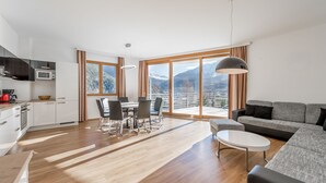 A modern apartment with a kitchen, dining area, and living room with a large window offering a mountain view. - Apart Hotel Garni Wieser - Sölden (Soelden)