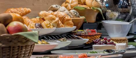 A buffet with various food items including bread, cheese, and fruits.
