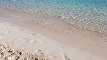 Privat strand, vit sandstrand, solstolar och strandhanddukar