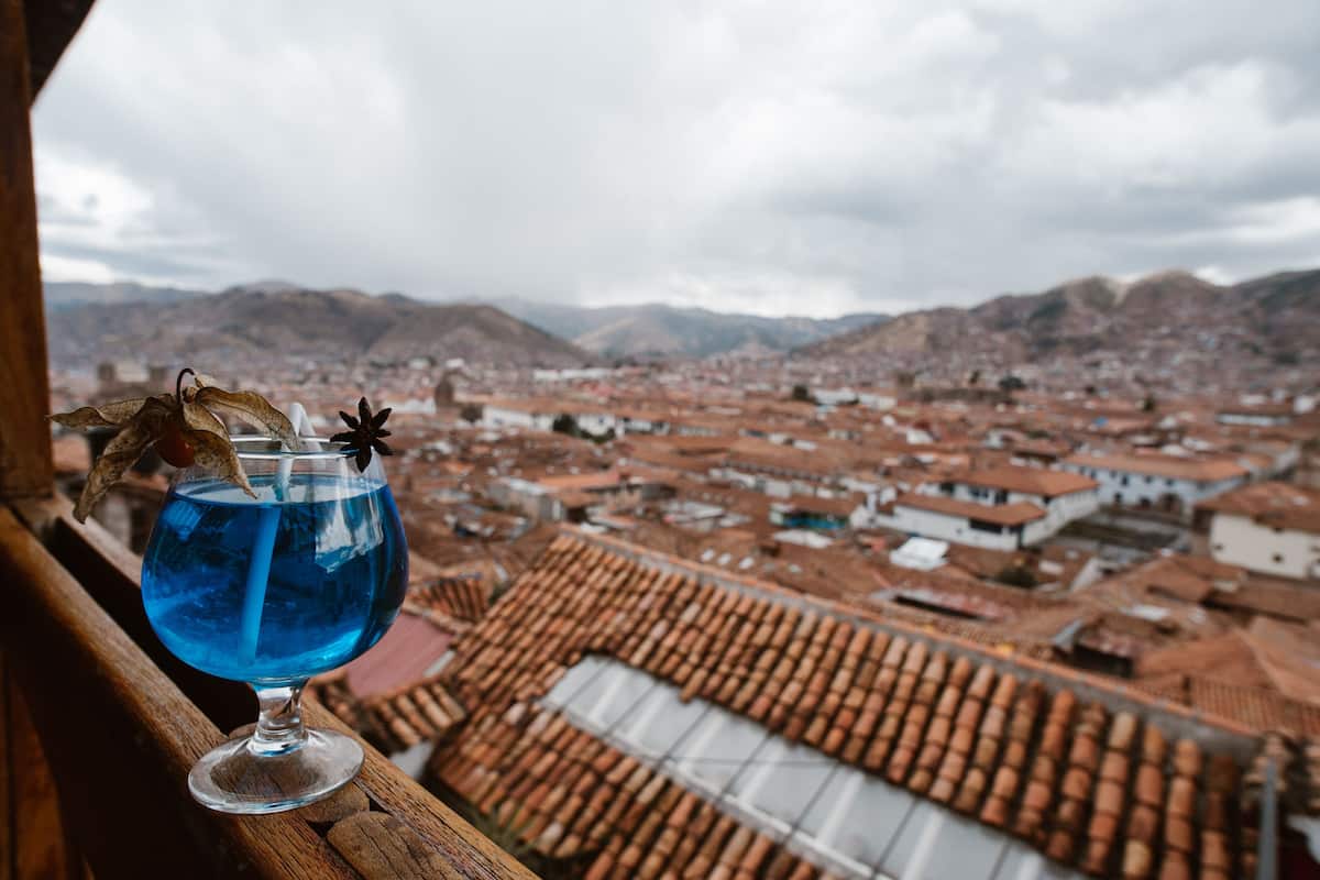 Vista de una ciudad con edificios de tejados rojos desde un balcón.