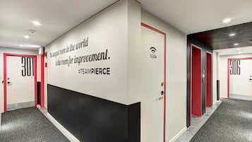 A hallway with doors numbered 300 and 306, a wall with a quote about teamwork, and a logo for Telecom.