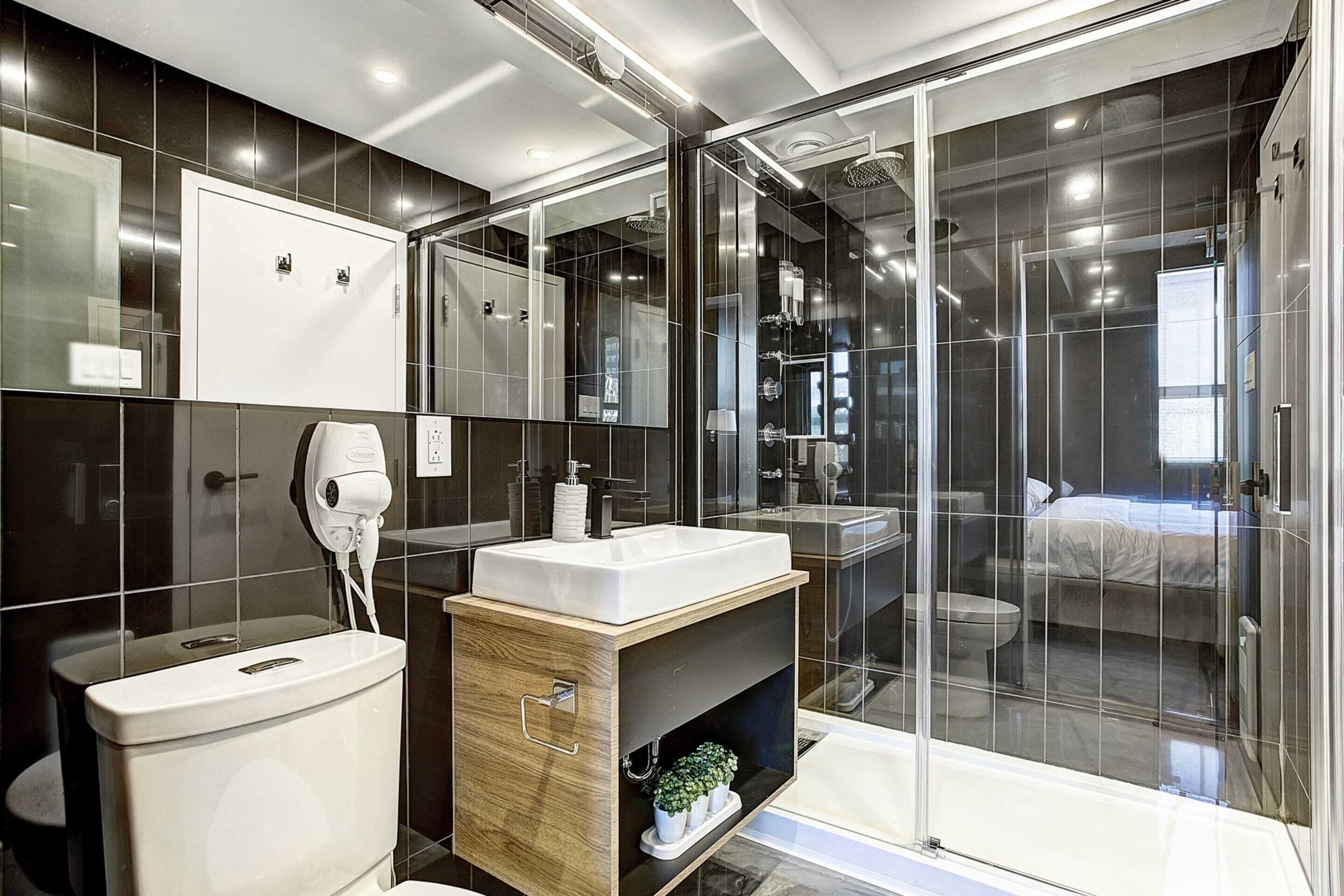 Ein modernes Badezimmer mit einer gläsernen Dusche, einem weißen Waschbecken und einem Holzlager.