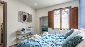 A bedroom with a bed, a dresser, a mirror, and a window with wooden shutters. - Dreamy Guelfa by Mmega (Florence)