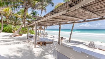 Playa privada, playa de arena blanca, camastros y sombrillas