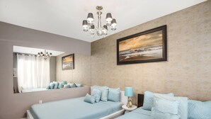 A bedroom with two beds, a chandelier, a large mirror, and a painting on the wall. - Apartment on the Beach (Miami Beach)