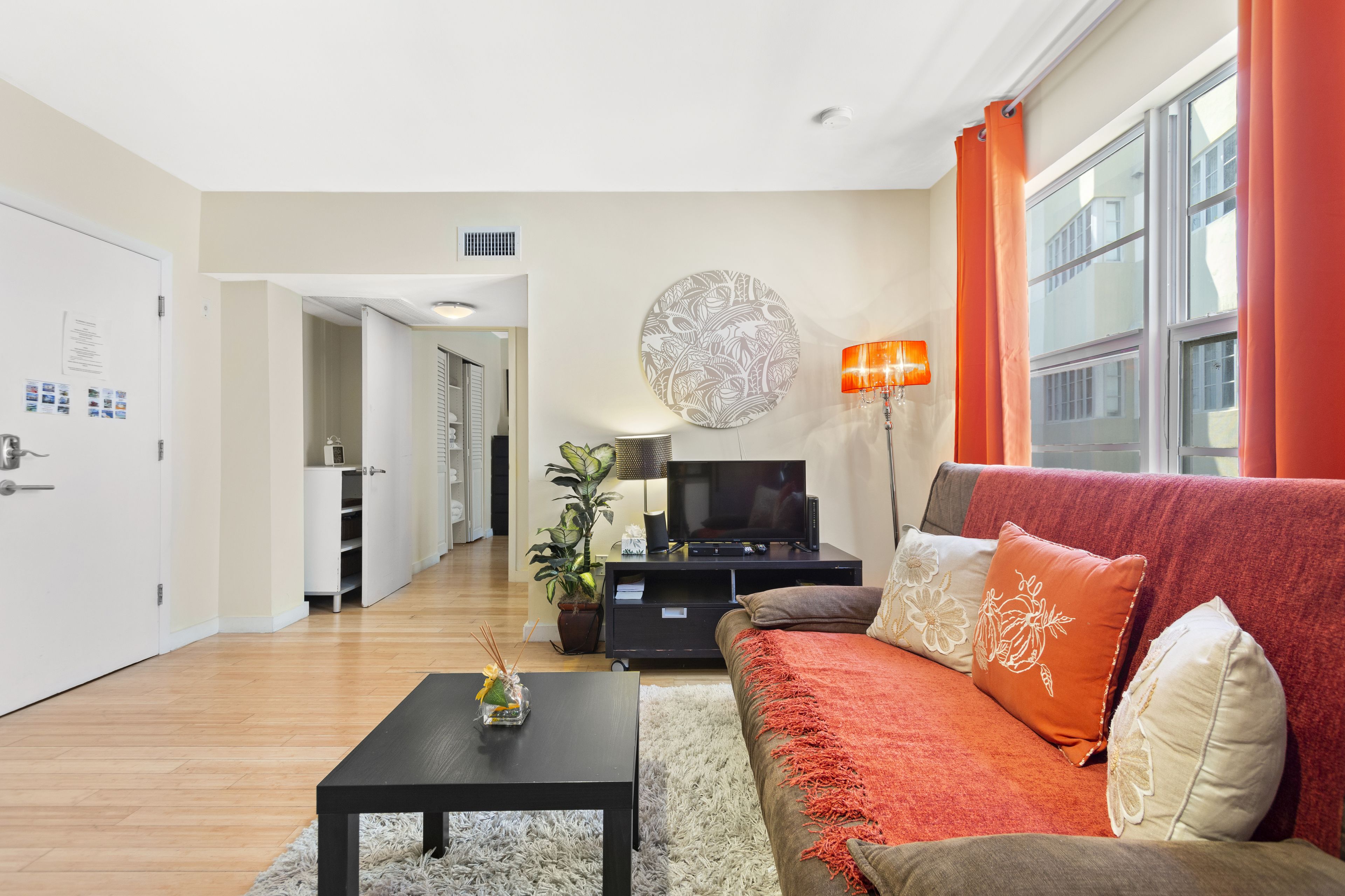 A modern living room with a sofa, coffee table, TV, and a decorative wall piece.
